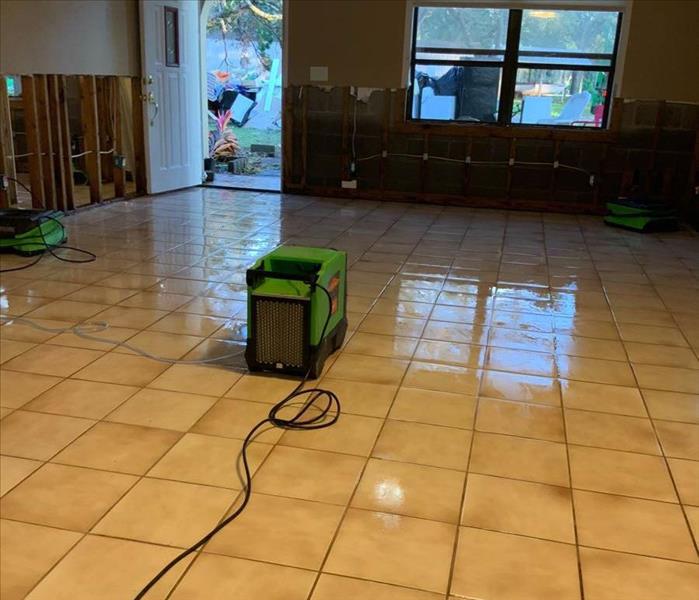 Wet floor, flood cuts, and green equipment on floor.