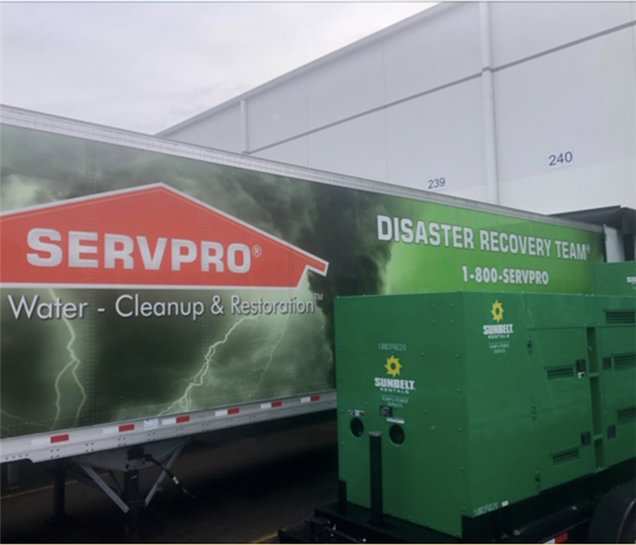 A Disaster Recovery Team trailer parked outside a commercial building with large loss equipment beside it.