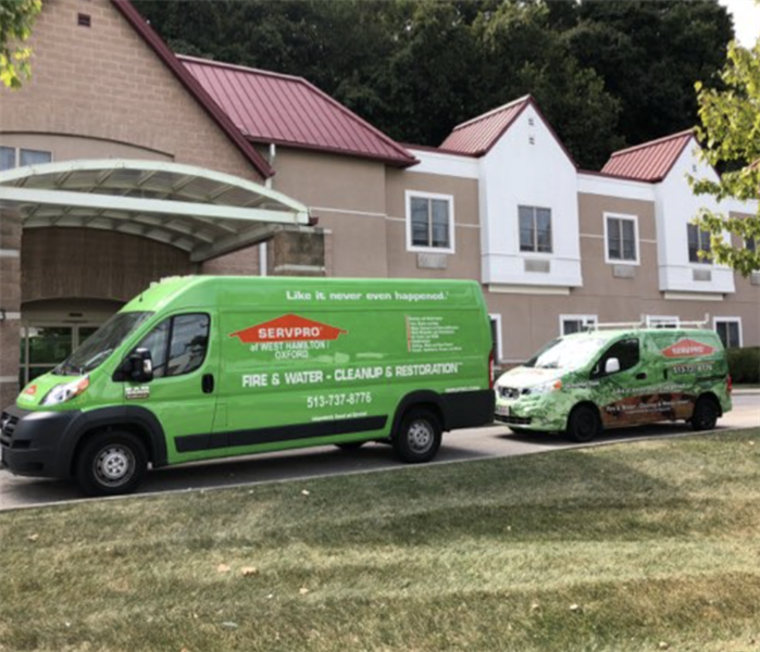 SERVPRO vehicles parked outside structure.
